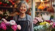 portrait of a happy adult woman who owns a flower shop, standing and smiling at the camera in front of her flower shop