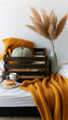 A cozy autumn breakfast scene. Place a wooden crate on a bed, covered with a mustard yellow knit throw