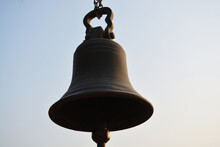 A Big Antique Brass Bell Hanging Against The Sky