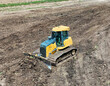 Bulldoser excavator moving dirt around to level out a field