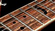   A close-up view of a guitar's neck and its frets
