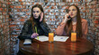 girls talking on their cell phones in a cafe.