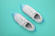 Sneakers in shoe covers on turquoise background, top view