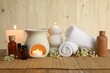 Aromatherapy. Scented candles, bottles, flowers and towels on wooden table