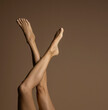 Bare female legs, top view on a beige background.