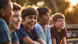 © Nemanja - Group of five multiethnic diverse preteen tween boys laughing, friends sitting together outdoors on a wooden bench in a park at the sunset. Community happiness and joy, summer leisure hanging out