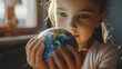 little girl with a representation of the planet earth in her hands with a surprised look - concept of caring for the environment