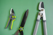 Pruning Tool. Secateurs, loppers and hedge trimmers on a green combined background.Garden equipment and tools. Tools for pruning and trimming plants.