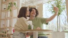 Couple In Love Taking A Selfie In A Cafe. Funny Guy And Girl Taking Selfie On Smartphone In Restaurant. Cute Couple Enjoy A Lunch Date