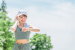 公園でトレーニング・ジョギングのインターバル中にスマートウォッチを確認する若いアジア人女性
