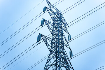 High voltage transmission towers on the background of the blue sky.