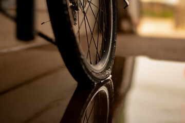 Wall Mural - close up of rear bicycle wheel which is flat and parked on wet floor of house garage.