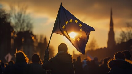 Silhouetted against the rising sun, a woman holds the European flag amidst a crowd, symbolizing unity and hope for a new day