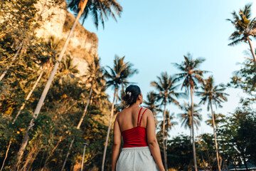 Wall Mural - Woman with coconut trees, walkway to the beach