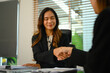 Attractive businesswoman shaking hands with her business partner during a meeting