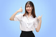 Portrait Asian student girl with Thai university uniform thumbs up isolated on blue background.