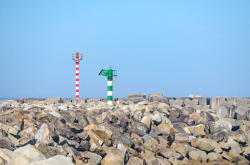 Fototapete - view of the stone blocks and lanterns of a port breakwater with blue sky background