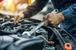 © ttonaorh - Auto mechanic repairing car engine in auto repair shop. Car service and maintenance concept