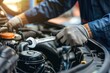 © ttonaorh - Auto mechanic repairing car engine in auto repair shop. Car service and maintenance concept