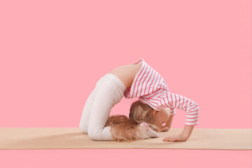 Poster - Cute little girl with mat practicing yoga on pink background