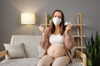 Sick ill unhealthy Caucasian pregnant woman sitting on sofa at home holding nasal spray and spray for inhalation taking care of her health during pregnancy flu
