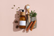 Beautiful composition with bottle of natural cosmetic products, cinnamon sticks and stone on beige background