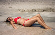beautiful girl in red bikini relaxes by the sea