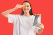 Young woman with potato chips on red background