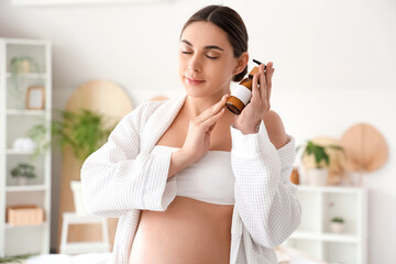 Sticker - Young pregnant woman with bottle of cosmetic product in spa salon