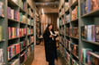 Pretty teen gen Z Korean student girl chooses book in a bookstore. Education training concept. Part of a series