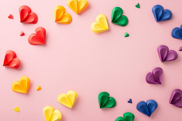 Sticker - Vibrant arrangement of paper hearts in rainbow colors spread across a pink backdrop, symbolizing love and diversity for Pride Month