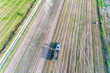 aerial drone view of a tractor with a combine harvester harvesting potatoes