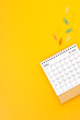 May 2024 desk calendar and paper clips on yellow background. Position with copy space.