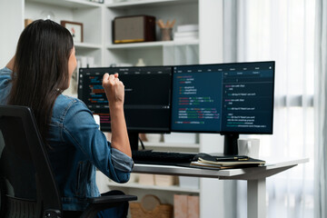 Wall Mural - Young Asian IT developer creating raising fist up with successful information on pc with coding program information data application, wearing jeans shirt surround safety analysis screen. Stratagem.