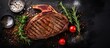 Juicy steak with seasonings and tomatoes on dark backdrop
