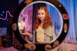 Portrait of stylish teen girl standing in her room posing for camera, through circle lamp medium shot