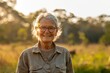 A radiant senior woman with grey hair smiles with nature's golden hour light illuminating her