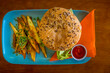 Hamburger with french fries and ketchup on a blue plate with orange napkins