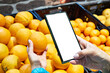 Orange fruit in hand and smartphone
