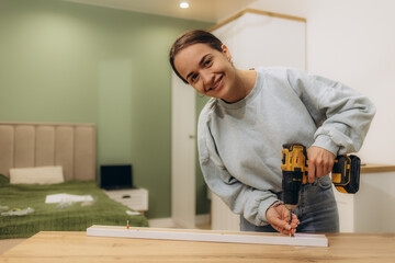 Woman reading an instruction manual to assemble furniture