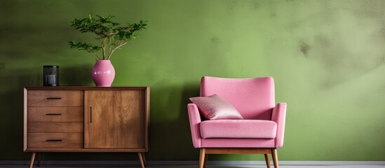Poster - Pink chair and wooden cabinet against green wall