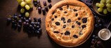 Fototapeta Dinusie - Pie with grapes and fruit on table