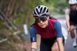 young asian female cyclist riding bike outdoors on rural road