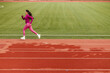 A sportswoman with healthy habits is running fast at the stadium.