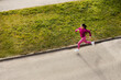 Top view of a sportswoman running on the street.