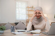 A young Muslim business woman is stressed and has a headache from miscalculating business numbers and problems with company expenses.