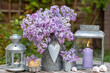 romantisches Garten-Arrangement mit Flieder-Strauß und vintage Zink-Laternen