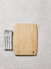 Wall Mural - Wooden cutting board on the decorative table, view from above, napkin, empty, textured background.