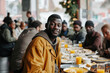 Positive homeless black man standing at the table in a street dining hall, surrounded by other individuals