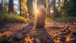 Close up of man's feet in hiking boots walking on forest path at sunrise